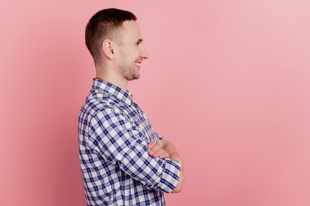Profile side photo of young man happy smile crossed arms confident look empty space isolated on pink color background