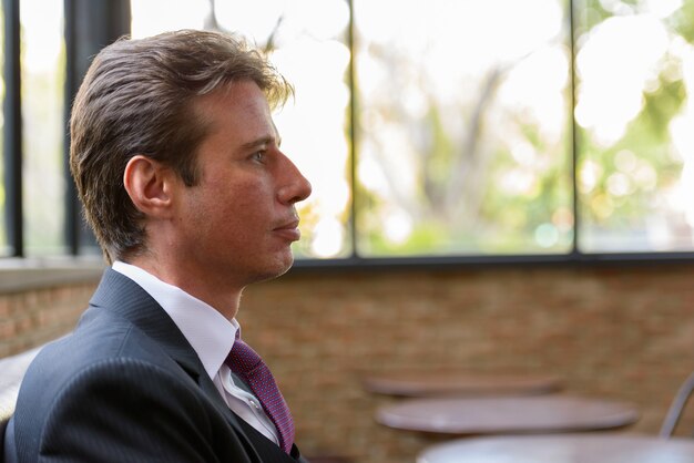 Profile view of businessman face sitting in coffee shop