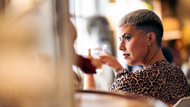 Profile view of a hipster woman with short hair in a bar