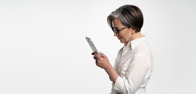 Profile view of serious woman working with digital tablet