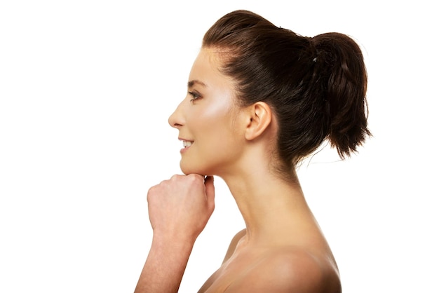 Profile view of thoughtful woman with hand on chin against white background