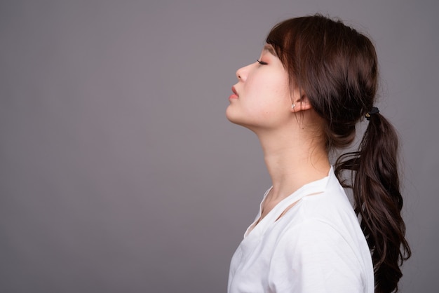 Profile view of young beautiful Asian woman with eyes closed