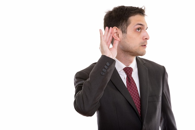 Profile view of young curious businessman listening