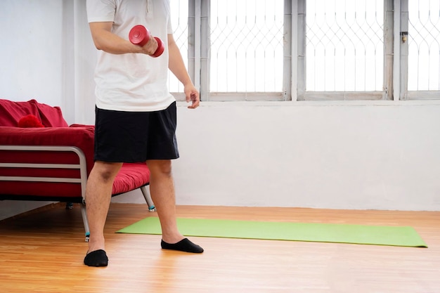 Vista di profilo di un uomo giovane e in forma che fa affondi in ginocchio