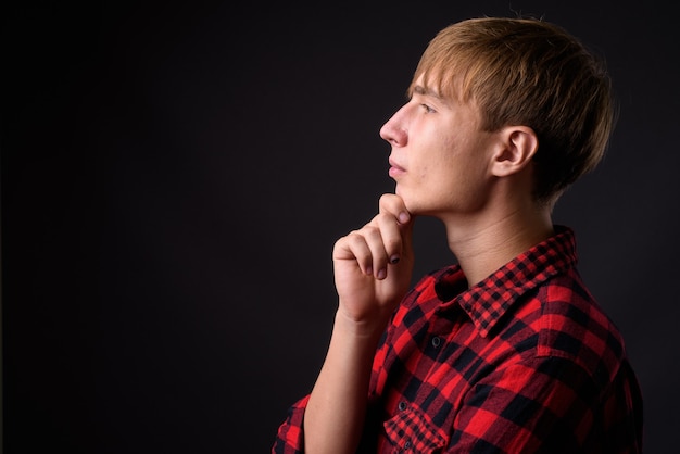 Profile view of young handsome man with blond hair thinking