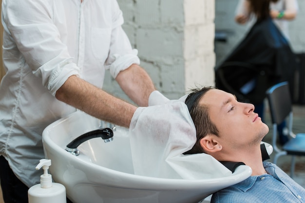 Profile view of a young man getting ready for his hair washed