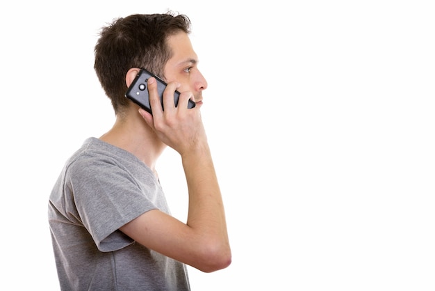 Vista di profilo del giovane uomo che parla al telefono cellulare