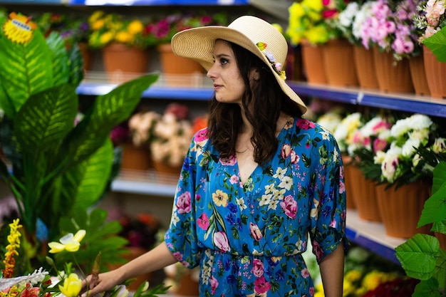 Profile of a woman in straw hat in a florist's shop