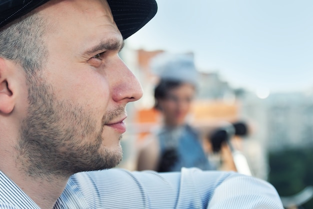 Profile of young bearded man in a cap