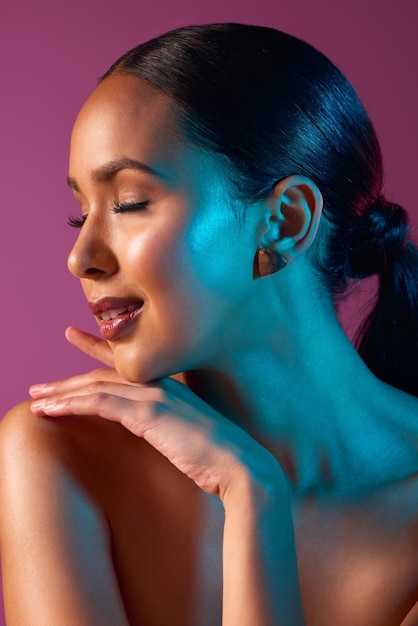 Profiling perfection Cropped shot of an attractive young woman posing in studio against a pink background