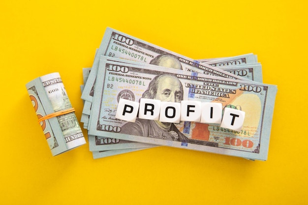 Profit word with stack of usd on yellow background business profit
