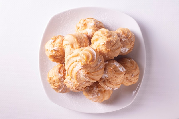 Profiteroles met room op witte keramische plaat