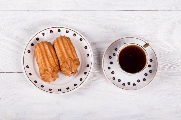 Foto profiteroles met slagroom op tafel bij een kopje koffie