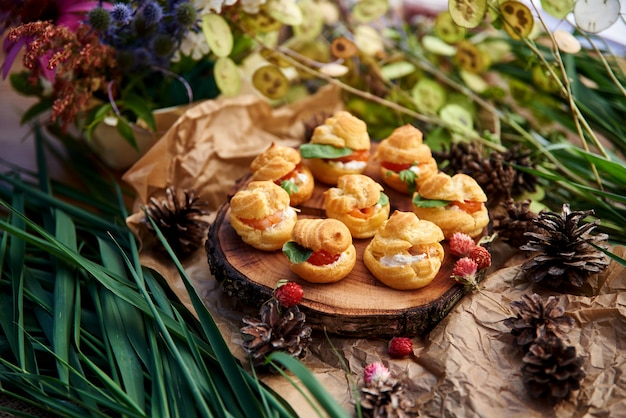 Profiteroles con formaggio a pasta molle, pesce rosso ed erbe. un pasto gourmet per la tavola delle vacanze.