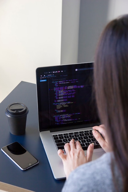 Foto un programmatore che codifica su un laptop sul posto di lavoro