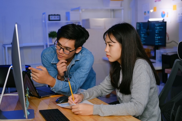 Programmer and developer teamwork working in a software development and coding technologies at night.