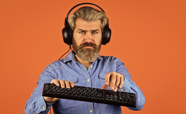 Programmer typing on keyboard digital music creation man listen
headphones and keyboard communication concept support call center
and customer service help desk gamer playing computer game