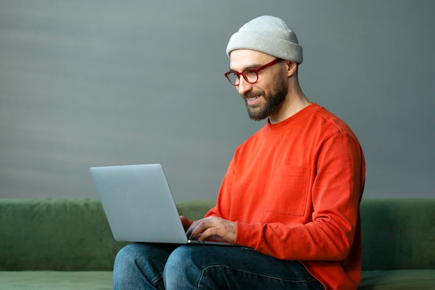 Programmer using laptop computer typing on keyboard working freelance project sitting at workplace