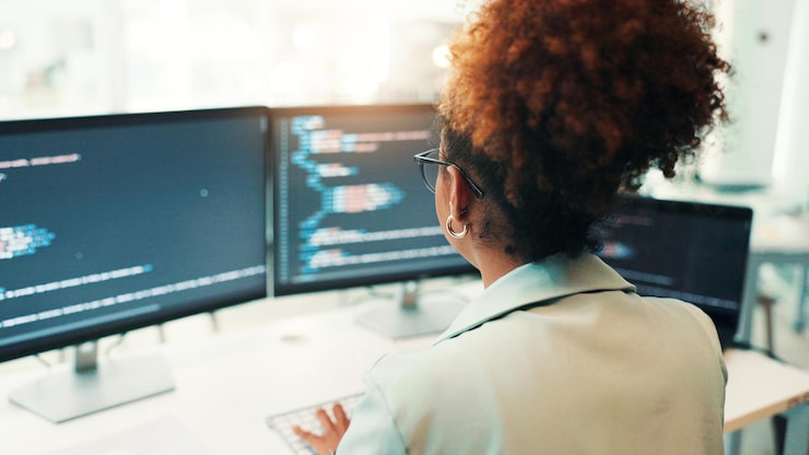 Photo programmer woman and computer screen with typing in office for writing code app development and debugging back programming and employee with data analytics for software testing and system update