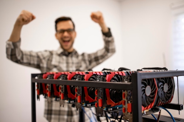 Programmer working on his cryptocurrency mining rig checking bitcoin value and earnings