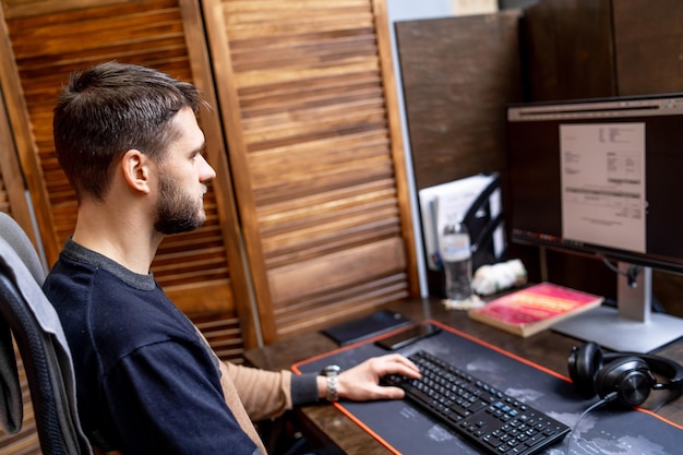 Программист, работающий в офисе компании по разработке программного обеспечения, смотрит на экран и пишет код. Концепция дизайна сайта