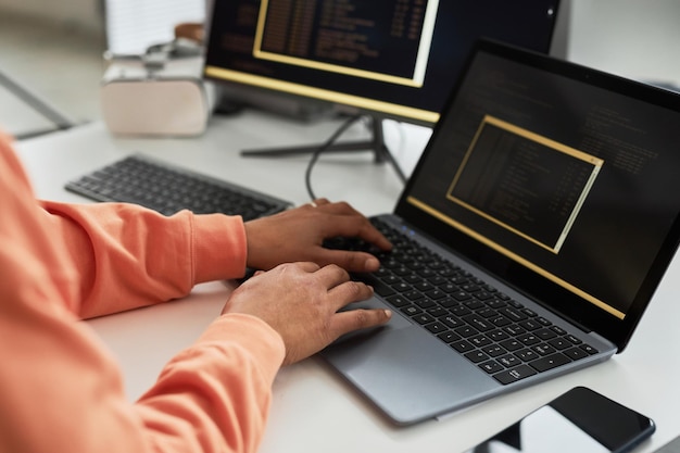 Programmer writing code on laptop