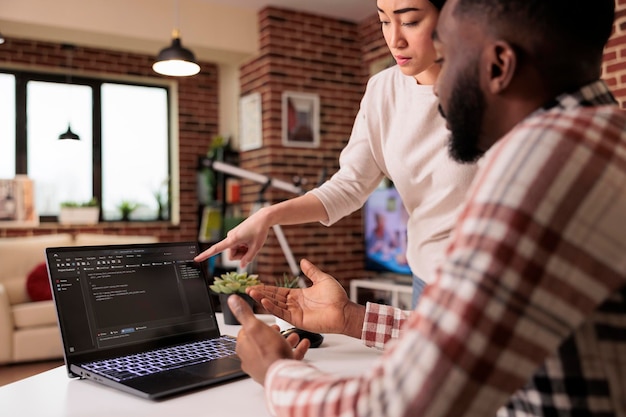 Photo programmers couple coding security firewall on laptop, using html and temrinal window to develop new user interface. learnign to program software using cloud computing app server.