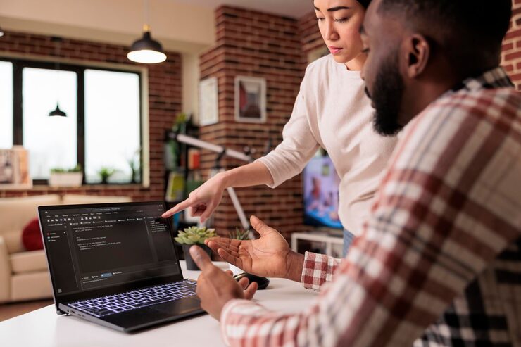 Photo programmers couple coding security firewall on laptop, using html and temrinal window to develop new user interface. learnign to program software using cloud computing app server.
