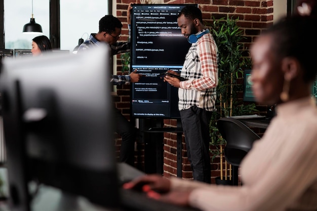 Programmers looking for source of cyber attacks and system security coverage. Software developer team members programming encryption applications to be used as security measure.