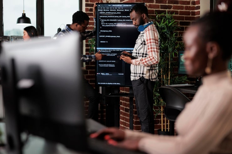 Photo programmers looking for source of cyber attacks and system security coverage. software developer team members programming encryption applications to be used as security measure.
