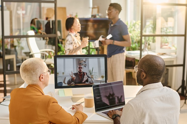 Programmers talking online with colleague during online meeting