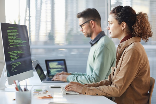 Foto i programmatori che lavorano sul computer in ufficio it digitando la codifica dei dati nel software