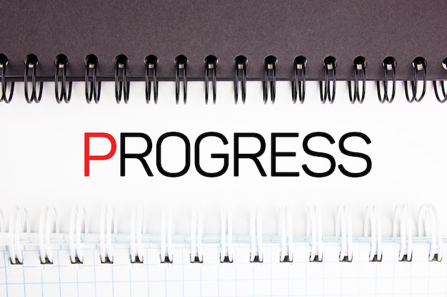 PROGRESS tex concept between two notebooks stationery notepads Concept text of progress achievement