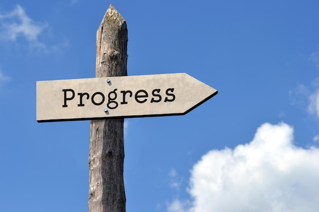 Progress wooden signpost with one arrow sky with clouds