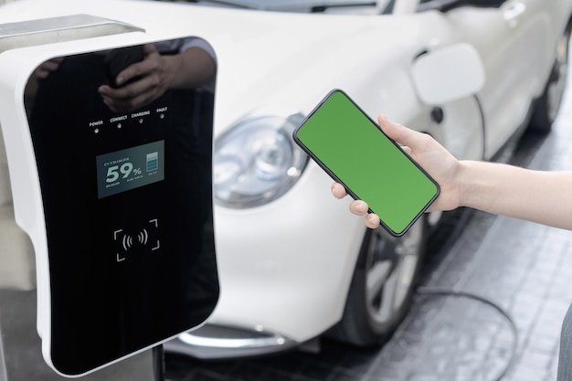 Progressief concept van groen scherm mockup telefoon EV auto en laadstation