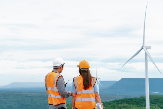 Progressief concept van ingenieurs die werken in het windpark bovenop de berg