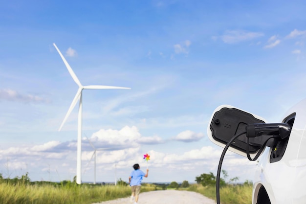 Progressieve jonge Aziatische jongen spelen met wind pinwheel speelgoed op windturbinelandbouwbedrijf