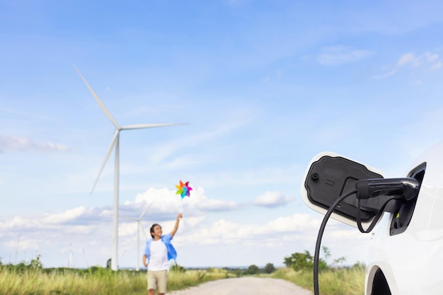 Progressieve jonge Aziatische jongen spelen met wind pinwheel speelgoed op windturbinelandbouwbedrijf