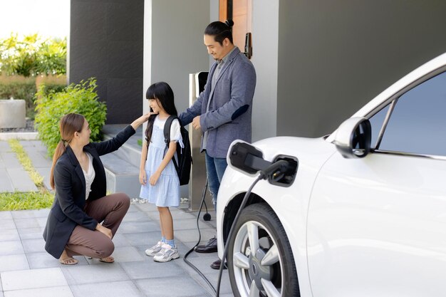 Progressieve jonge ouders en dochter wonen in een huis met een elektrische auto