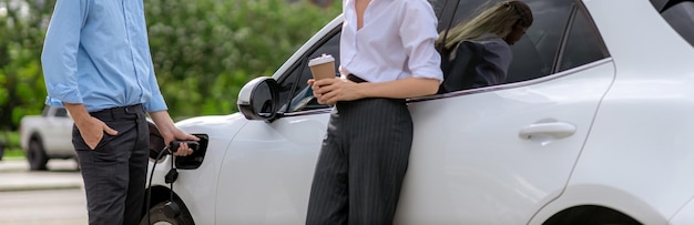 Progressive businessman and businesswoman with coffee at public charging station