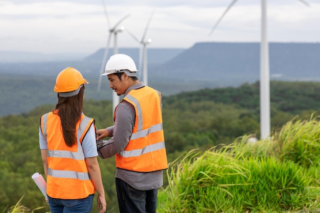Progressive concept of engineers working in the wind farm atop of the mountain