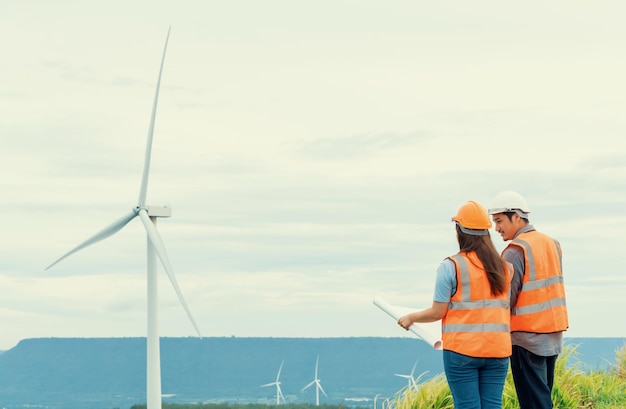 Progressive concept of engineers working in the wind farm atop of the mountain