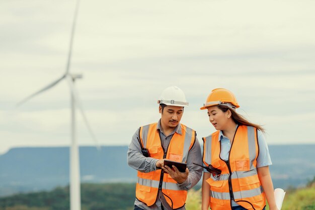 Progressive concept of engineers working in the wind farm atop of the mountain