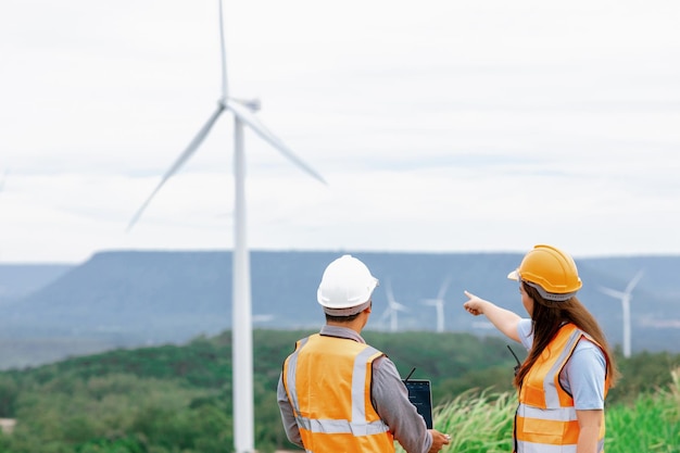 Progressive concept of engineers working in the wind farm atop of the mountain