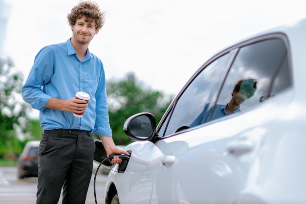 Progressive concept of EV car at charging station with blur man background