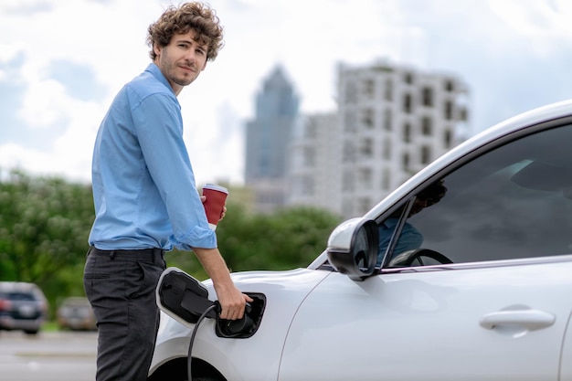 Progressive concept of EV car at charging station with blur man background