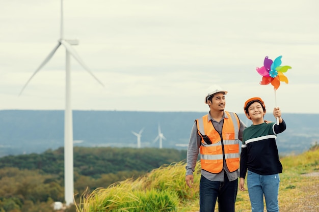 Progressive engineer with his son holding windmill toy in the mountain