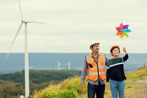 Progressive engineer with his son holding windmill toy in the mountain