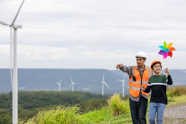 Progressive engineer with his son holding windmill toy in the mountain