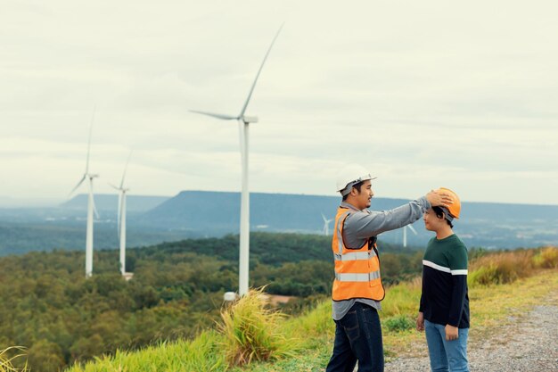 Progressive engineer with his son in the wind farm atop of the mountain